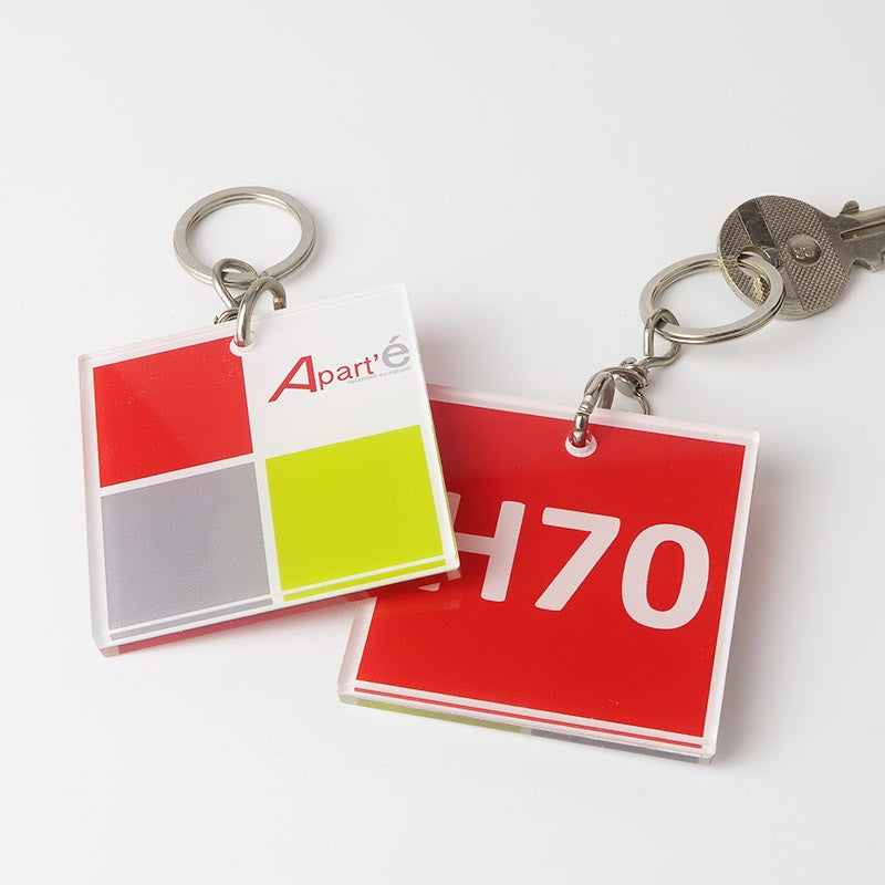 Porte-clé carré avec une personnalisation nette et élégante du logo de la résidence Apart’é et son numéro de chambre