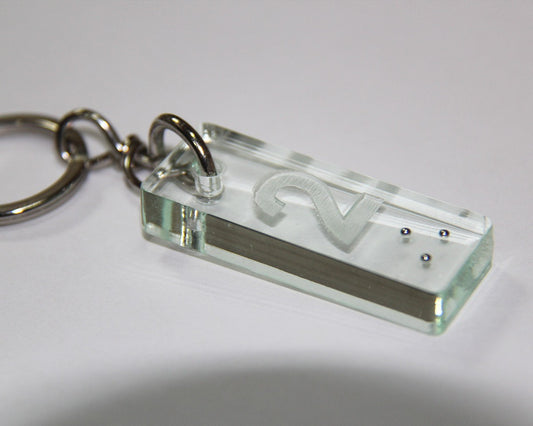 Petit porte-clé complémentaire en plexiglass, avec numéro gravé en relief et marquage en braille, idéal pour une identification tactile.