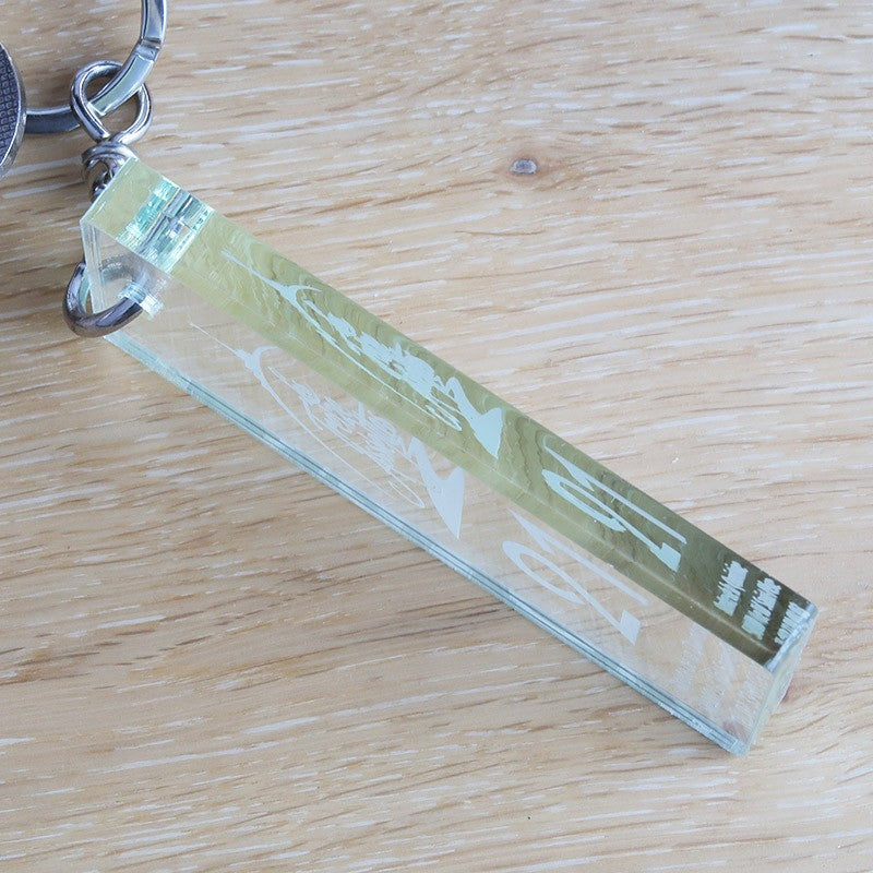 Vue latérale du porte-clé montrant l’épaisseur de 6 mm, soulignant la solidité du plexiglass et la précision de la gravure laser.