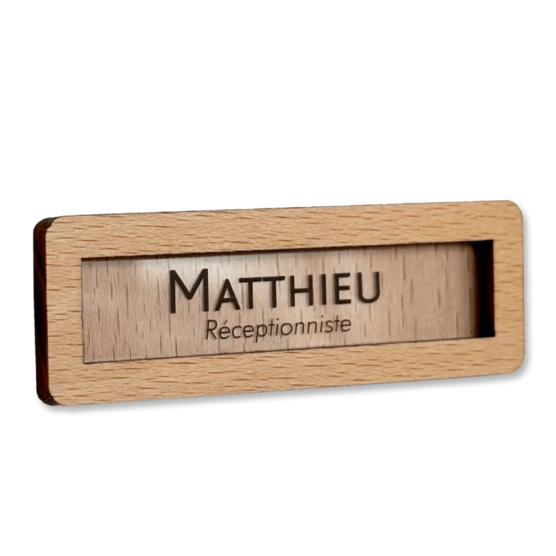 badge en bois 1er prix sans logo, avec étiquette interchangeable insérée à l’avant.