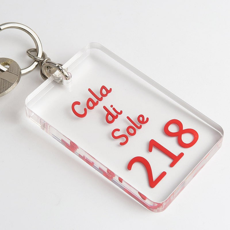 porte-clés Créolaz rectangulaires en plexiglas transparent, prêts à l'utilisation, montrant la qualité de fabrication et la personnalisation en volume pour un établissement hôtelier.