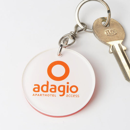 Gros plan sur le logo ADAGIO intégré sur le porte-clé, démontrant la qualité du marquage et la lisibilité des détails