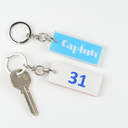 Gros plan sur le porte-clé montrant les détails du logo CAPFUN en impression numérique UV, soulignant la qualité du marquage.