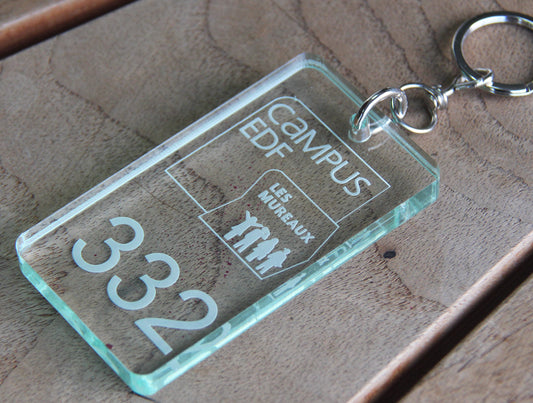 Porte-clé de 8 cm x 5 cm en plexiglass transparent, gravé avec le logo EDF et le numéro d'identification, prêt pour une utilisation professionnelle.