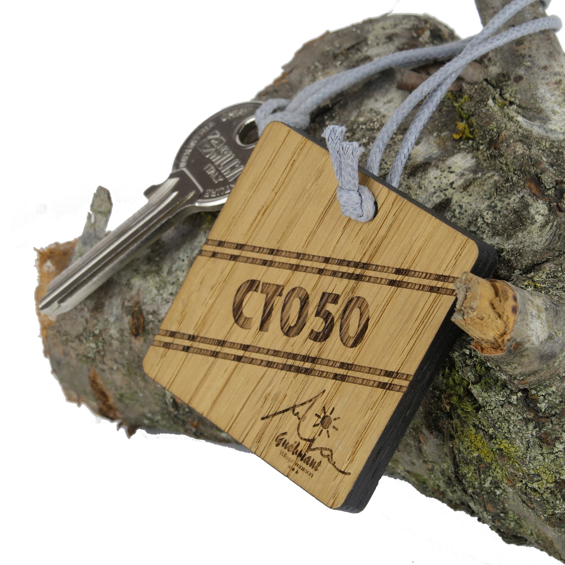Porte-clé CréoBois attaché à une clé de logement dans une résidence de vacances, montrant son utilisation pratique dans un environnement de loisirs.