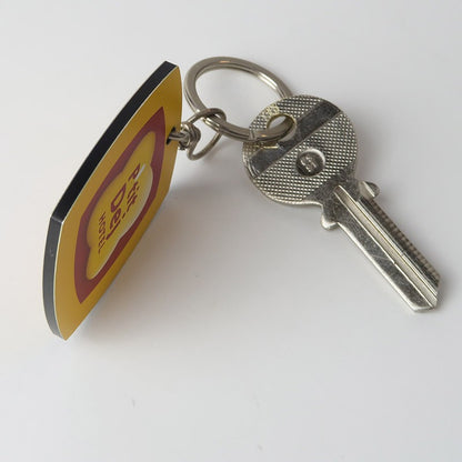 Vue latérale du porte-clé montrant l’épaisseur du matériau léger et la qualité du système de fixation avec anneaux, brisée et tourillon.