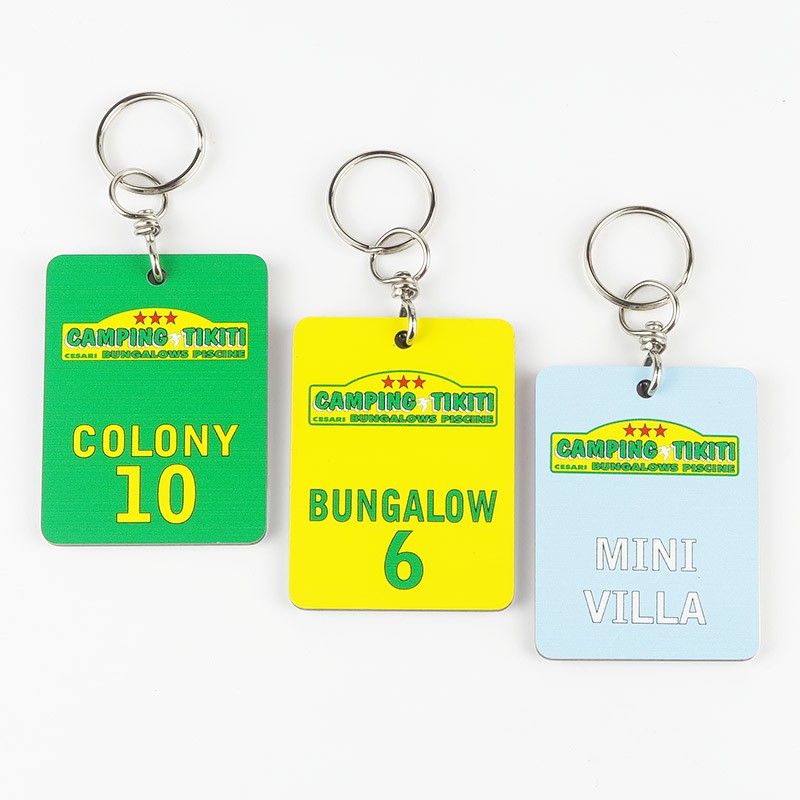 Ensemble de plusieurs porte-clés alignés avec des couleurs de fond différentes, chaque couleur représentant une zone distincte du camping